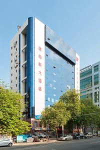 un edificio alto con escritura roja en el costado. en Guangzhou Compass Hotel, en Guangzhou