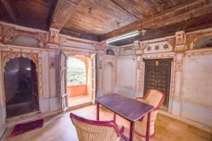 a room with a table and two chairs and a television at Hotel Suraj in Jaisalmer