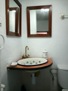 bagno con lavandino, servizi igienici e specchi. di Alojamiento rural El Batán a Priego de Córdoba