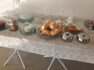 a table with a plate of croissants and other foods at Hotel Pousada Braúna in Braúna