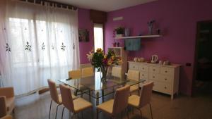 uma sala de jantar com uma mesa de vidro e cadeiras em L'Isola di Romy em Milão