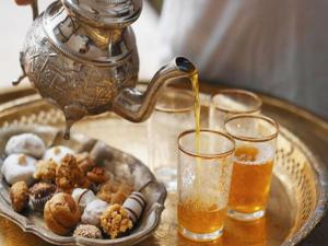 un bollitore per il tè e un piatto di cibo con bevande di Riad Wink a Marrakech