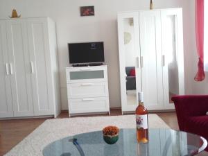 a living room with a glass table and a television at Éger Apartman in Eger