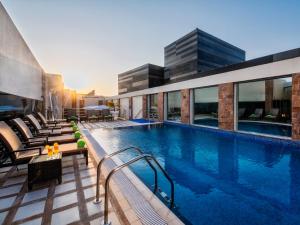 a swimming pool on the roof of a building at Golden Tulip Doha Hotel in Doha