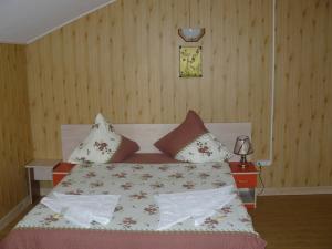 Un dormitorio con una cama con almohadas. en Pensiunea ,,La struti" en Tîrgu Neamţ