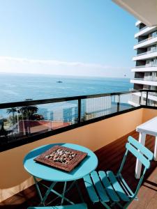 een tafel en stoelen op een balkon met uitzicht op de oceaan bij Fantastic SEA VIEW Studio in Funchal in Funchal