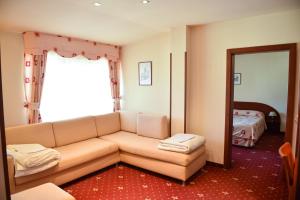 ein Wohnzimmer mit einem Sofa und einem Bett in der Unterkunft Martin Club Hotel in Bansko