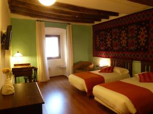 a hotel room with two beds and a window at Cal Maginet in Vilavert