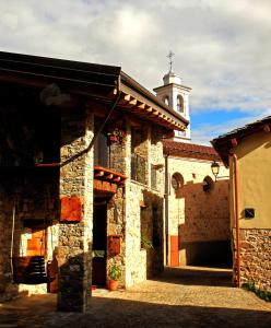 un antiguo edificio de piedra con una torre de reloj en el fondo en Affittacamere La Lea, en Roccaforte Mondovì