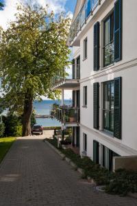 a building with a tree next to a street at Villa Friede_Marie_ App_ Meere in Sassnitz