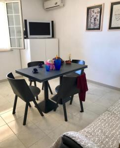 a dining room table with chairs and a refrigerator at Da Paolo e Antonietta in Mazara del Vallo