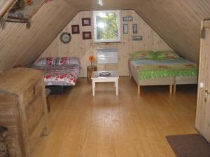 a attic room with two beds and a table at Lonni Nature Eco-Accommodation in Hagudi