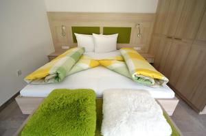 a bedroom with a large bed with green and yellow pillows at Panoramahof in Kastelbell-Tschars