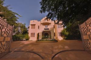une entrée dans un bâtiment rose avec deux portes dans l'établissement Visalam Chettinad Palace - CGH Earth, à Chettinadu