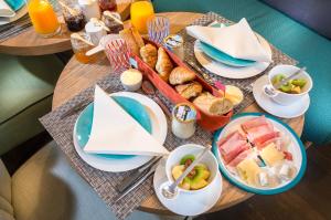a table with plates of food and a tray of breakfast foods at 1er Etage SoPi-Montmartre in Paris