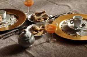 a table with plates of food and glasses of orange juice at B&B Edera in Castagnole Piemonte