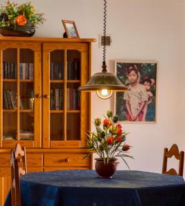 ein Esszimmer mit einem Tisch und einer Vase mit Blumen in der Unterkunft Markádia in Odivelas