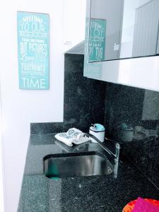 een badkamer met een wastafel en een bord aan de muur bij Fantastic SEA VIEW Studio in Funchal in Funchal