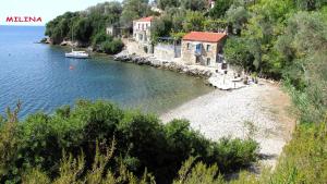 a beach with houses and a boat in the water at Notus Villa in Chorto