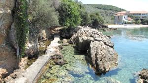 a body of water with rocks and water at Notus Villa in Chorto