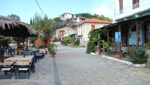 an empty street with tables and chairs and buildings at Notus Villa in Chorto