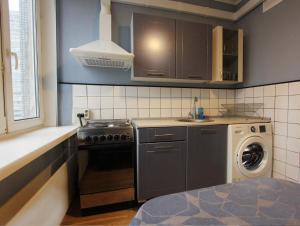 a kitchen with a stove and a washing machine at Apartlux on Novy Arbat Street in Moscow