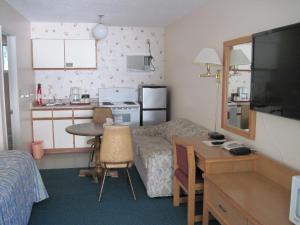 a small room with a bed and a table and a kitchen at Alpine Motel in Hope