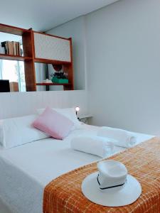 een wit bed met een hoed erop bij Fantastic SEA VIEW Studio in Funchal in Funchal