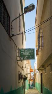 un vicolo con un cartello sul lato di un edificio di La Colombe Blanche a Moulay Idriss Zerhoun