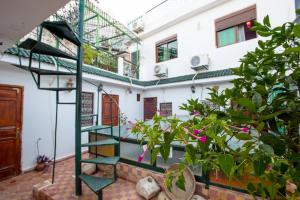 une chambre avec un escalier et des plantes devant un bâtiment dans l'établissement La Colombe Blanche, à Moulay Idriss Zerhoun