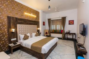 a bedroom with a large bed and a television at Hotel Castle Inn in Udaipur