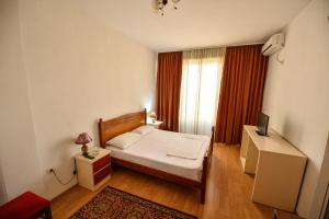 a small bedroom with a bed and a window at Hotel Argenti in Shkodër