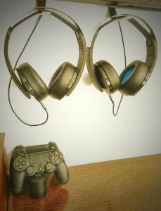 a pair of headphones and a video game controller under a light at MB Boutique Hotel - Adults Recommended in Nerja