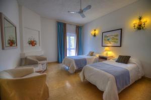 a hotel room with two beds and two lamps at Hotel Ta' Cenc & Spa in Sannat