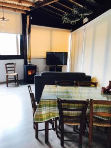 - un salon avec une table, des chaises et un canapé dans l'établissement Xenios Guesthouse, à Koilani