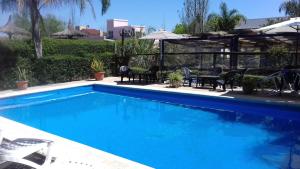 a large blue swimming pool with chairs and umbrellas at Paraiso Colon in Colón