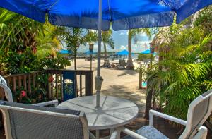 een tafel en stoelen met een parasol op het strand bij Island Bay Resort in Key Largo