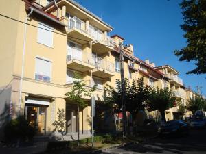 a yellow building with balconies on a street at HOLIV Apartman in Hévíz