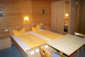 a bedroom with a bed and a table in it at Alpengasthof Brüggele in Alberschwende