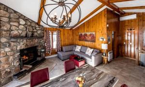 a living room with a couch and a stone fireplace at Chalets Lac à la Truite in Sainte-Agathe-des-Monts