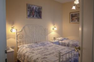 ファッラ・ダルパーゴにあるB&B Villa al Lagoのベッドルーム1室(ベッド2台付)が備わります。壁には絵画が飾られています。