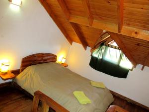 1 dormitorio con 1 cama en una habitación con techos de madera en Alto Rolando Apartamentos en San Carlos de Bariloche