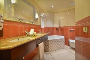 a bathroom with a sink and a tub and a toilet at Zvon Design Suites in České Budějovice