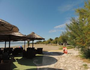 una playa con sillas y sombrillas en la arena en Lavander Apartments Omiš, en Duće