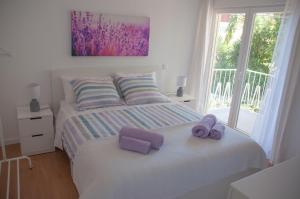 a bedroom with two beds with purple towels on them at Pine Tree Villa in Cascais