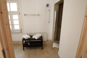 ein Badezimmer mit weißen Handtüchern auf einem schwarzen Kleiderständer in der Unterkunft Hotel Sudpfanne in Heidelberg
