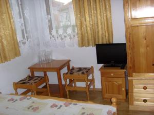 トリャブナにあるProboyski Guest Houseのベッドルーム(テーブル2台、椅子2脚、テレビ付)