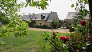 una vecchia casa con giardino e fiori di Grand Mainguet a Saint-Lambert-la-Potherie