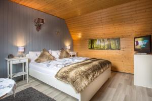 a bedroom with a bed and a tv in it at Pension Trautheim - Am Stadtpark in Bad Harzburg