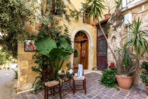 a patio with a table and chairs in front of a building at Ifigenia Traditional Rooms & Maisonettes in Chania